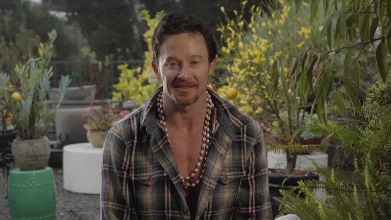 Still from the John Wolf Art Advisory retreat promo: John Wolf interviewed in a garden