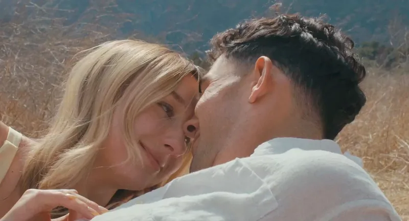 Still from the Won’t Forget About Me music video: a couple embracing in a golden field
